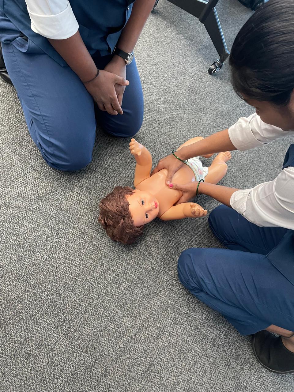 Hands-on infant first aid practice with a training doll